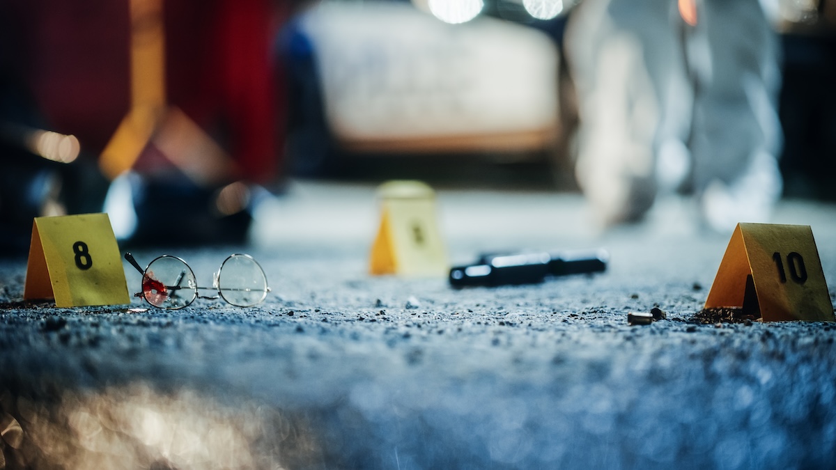 Crime scene from mugging gone wrong with bullet casings and broken glasses
