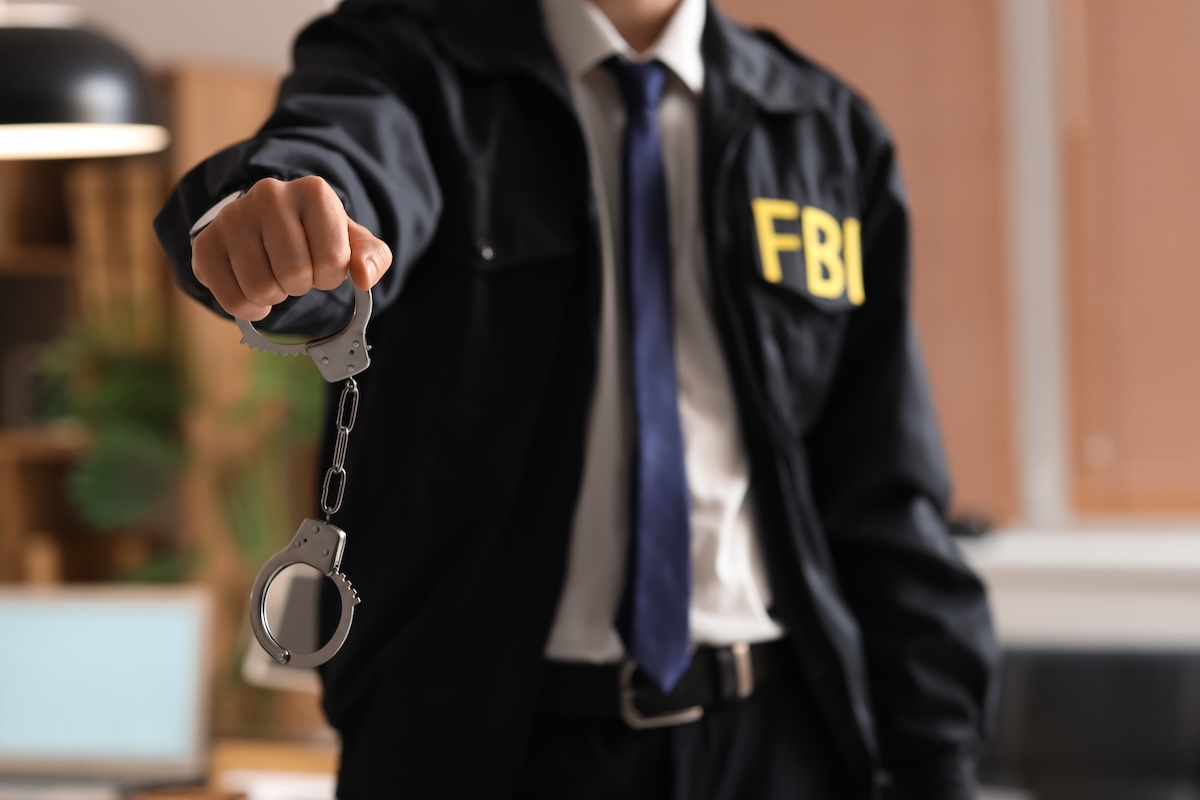 Male FBI agent with handcuffs in office, closeup