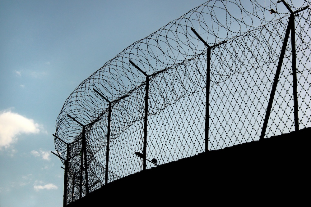 Silhouette of barbed wire on a prison fence