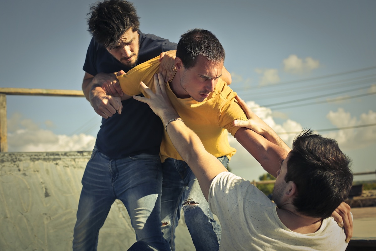 Three young guys in a fight