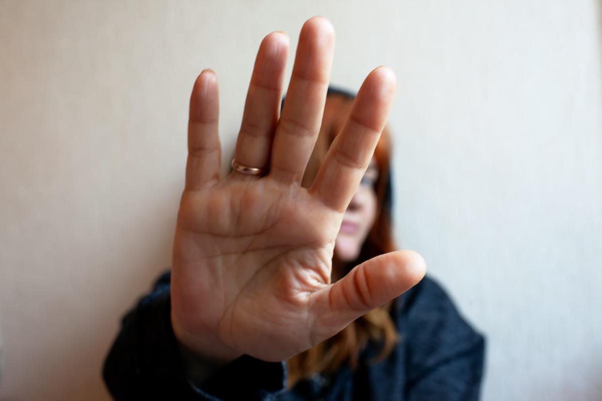 Young woman trying to hide her face with her hand