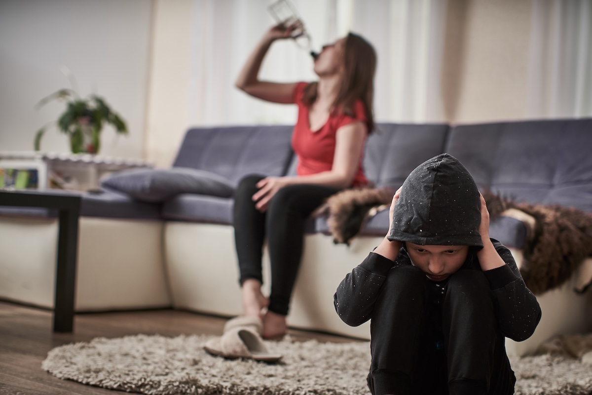 Child in distress while the mother drinks in the background
