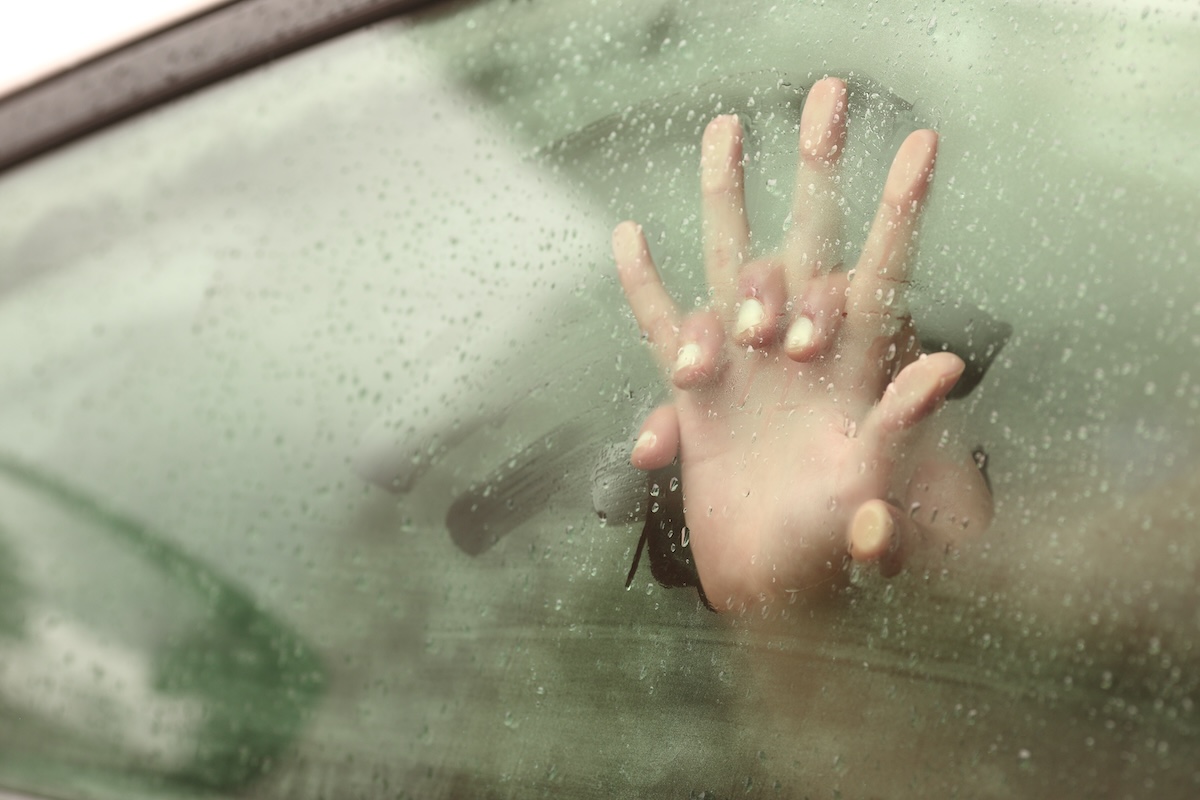 Couple holding hands inside a car with a steamy window