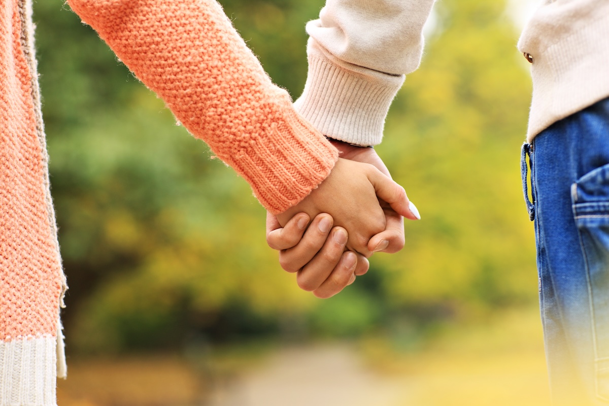 A picture of a couple holding hands in the park