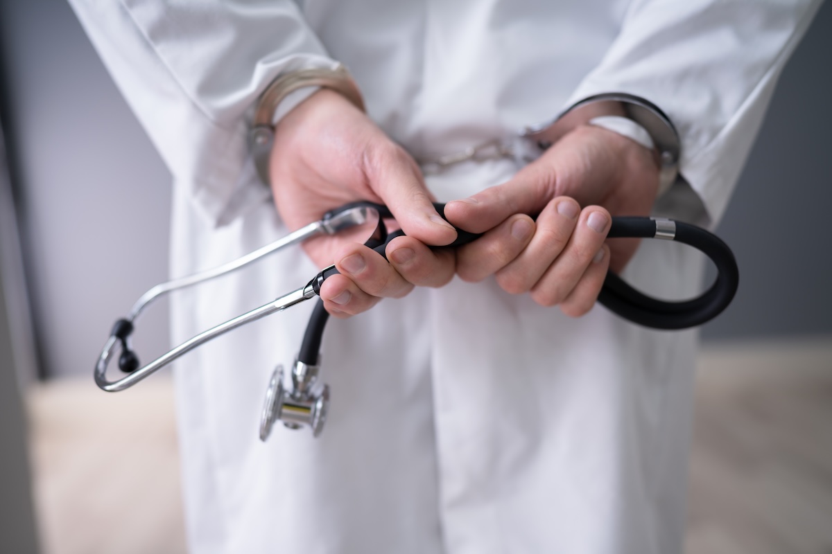 Close-up Of Doctor Hands With Stethoscope In Handcuffs