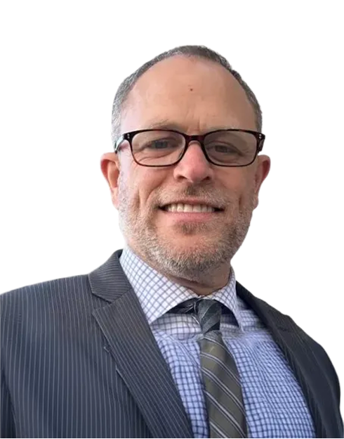 A man wearing glasses and a gray pinstripe suit with a checked shirt and striped tie, smiling at the camera against a plain white background.